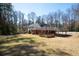 Backyard view featuring a deck, covered patio, brick exterior, and a spacious yard at 1276 Kingsview Se Cir, Smyrna, GA 30080