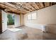 Unfinished basement with concrete floors, exposed ceiling, and an open door, showcasing potential for customization at 1276 Kingsview Se Cir, Smyrna, GA 30080