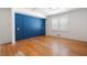 Bedroom featuring hardwood floors, white trim, and a unique blue accent wall at 1276 Kingsview Se Cir, Smyrna, GA 30080