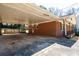 Spacious carport featuring brick construction and decorative iron supports adjacent to a wooden deck at 1276 Kingsview Se Cir, Smyrna, GA 30080