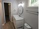 Bright bathroom features updated vanity with white marble countertop and decorative oval mirror above at 147 Mildred Ct, Dallas, GA 30157