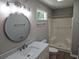 Well-lit bathroom features a marble countertop, stylish round mirror, and a shower with glass doors at 147 Mildred Ct, Dallas, GA 30157