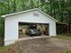 Exterior shot of a detached garage with a truck parked inside surrounded by trees at 147 Mildred Ct, Dallas, GA 30157