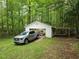 Exterior shot of a detached garage with a truck parked nearby surrounded by trees at 147 Mildred Ct, Dallas, GA 30157