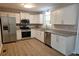 Bright kitchen with stainless steel appliances, granite counters, and white cabinets at 147 Mildred Ct, Dallas, GA 30157