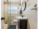 Compact bathroom with a glass-enclosed shower, modern vanity, and a sleek round mirror at 2114 Fellowship Rd, Tucker, GA 30084