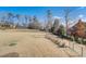 A view of a large backyard with a sloped lot featuring beautiful, mature trees on a sunny day at 2551 Kilgore Rd, Buford, GA 30519
