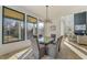 Modern dining room with glass table, gray chairs, statement lighting, and backyard views at 2551 Kilgore Rd, Buford, GA 30519