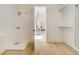 Bright laundry room with hardwood floors, white walls, washer/dryer hookups, and an open doorway to the rest of the house at 2551 Kilgore Rd, Buford, GA 30519