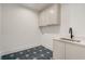 Well-organized laundry room with stylish blue tile flooring, ample cabinet space, and a modern sink for added convenience at 2551 Kilgore Rd, Buford, GA 30519