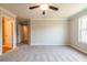A spacious bedroom with neutral walls and a ceiling fan, with two doorways on the back wall at 121 Priestwood Ln, Acworth, GA 30102