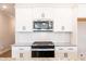 Modern kitchen featuring white cabinets, granite countertops, and stainless steel appliances at 121 Priestwood Ln, Acworth, GA 30102