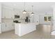 Bright, open kitchen with a large island, stainless steel appliances, and modern pendant lighting at 3188 Eastham Run Dr, Dacula, GA 30019