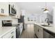 Modern kitchen featuring stainless steel appliances, white cabinetry, and a large island overlooking the living area at 3188 Eastham Run Dr, Dacula, GA 30019