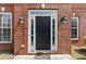 Elegant black front door surrounded by brick and sidelight windows at 4831 Edinburgh Dr, Smyrna, GA 30082