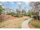 Serene backyard featuring a stone wall, lush greenery, and a paved path, offering a peaceful retreat at 5825 Laurel Oak Dr, Suwanee, GA 30024