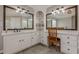 Bathroom featuring dual vanities, elegant mirrors, stylish lighting, and a comfortable seating area at 5825 Laurel Oak Dr, Suwanee, GA 30024