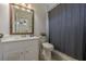 Cozy bathroom featuring a vanity, toilet, shower with curtain, and framed mirror at 5825 Laurel Oak Dr, Suwanee, GA 30024