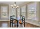 Dining area with hardwood floors, chandelier, and abundant natural light from the many windows at 5825 Laurel Oak Dr, Suwanee, GA 30024