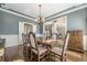 Traditional dining room featuring a rustic table, elegant chandelier, and easy access to other rooms at 5825 Laurel Oak Dr, Suwanee, GA 30024