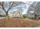View of an elegant home with manicured lawns, situated on a lush green hillside at 5825 Laurel Oak Dr, Suwanee, GA 30024