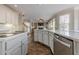 Well-lit kitchen with a stainless steel dishwasher, stone backsplash, hardwood floors, and an open layout at 5825 Laurel Oak Dr, Suwanee, GA 30024