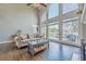 Sun-drenched living room with a large arched window, sofa, fireplace, and outdoor patio access at 5825 Laurel Oak Dr, Suwanee, GA 30024