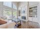 Spacious living room featuring built-in bookshelves, a fireplace, and a large window with views of the deck at 5825 Laurel Oak Dr, Suwanee, GA 30024