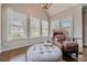 Comfortable sitting room featuring natural light, plush ottoman, and a leather armchair at 5825 Laurel Oak Dr, Suwanee, GA 30024