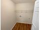 Compact laundry room with wood-look floors, a shelf, and a utility hookup at 624 Ironstone Dr, Fairburn, GA 30213