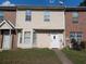 Two-story townhome with beige siding and brick accents under a blue sky at 8538 Westchester Dr, Douglasville, GA 30134