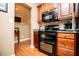 A well-equipped kitchen with wooden cabinets, black appliances, and tiled backsplash at 95 Gorham Gates Dr, Hiram, GA 30141