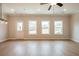 Living room with a back door and three windows looking out to the backyard, featuring light-colored LVP flooring at 109 Priestwood Ln, Acworth, GA 30102