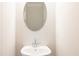 A cozy powder room with a pedestal sink and an oval mirror at 109 Priestwood Ln, Acworth, GA 30102