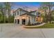 Exterior angle of three-car garage featuring a well-manicured lawn and spacious driveway at dusk at 3968 Ashford Dunwoody, Brookhaven, GA 30319