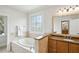 Bathroom featuring a soaking tub with decorative window, granite countertops, and wood cabinets at 2039 Fisher Ne Trl, Atlanta, GA 30345