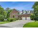 Brick home with a three-car garage, well-maintained landscaping, and a long driveway at 2039 Fisher Ne Trl, Atlanta, GA 30345