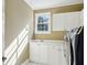 Bright laundry room with white cabinetry, sink, window, and modern appliances at 2039 Fisher Ne Trl, Atlanta, GA 30345