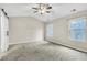 Bright bedroom featuring plush carpet, a ceiling fan, and two windows providing ample natural light at 2534 Grayton Loop, Villa Rica, GA 30180