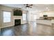 Open concept living area featuring a fireplace, modern lighting, wood-look floors, and kitchen view at 2534 Grayton Loop, Villa Rica, GA 30180