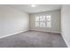 Empty bedroom with plush carpet and a large window overlooking the front yard at 4325 Bellview Ln, Duluth, GA 30097