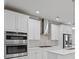 A kitchen with stainless steel appliances, white cabinets, and modern range hood at 4325 Bellview Ln, Duluth, GA 30097