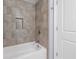 Close-up of the tile shower/tub featuring a chrome shower head and recessed niche at 4325 Bellview Ln, Duluth, GA 30097