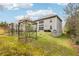 Exterior view of backyard and house with garden boxes, mature trees, and sloped landscaping at 5225 Tye Trl, Fairburn, GA 30213