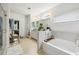 Bright bathroom featuring tiled floors, a separate shower, and a soaking tub at 5225 Tye Trl, Fairburn, GA 30213