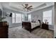 Luxurious main bedroom with tray ceiling, ceiling fan, and large window at 64 Roberson Ne Dr, Cartersville, GA 30121