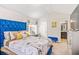 Bedroom featuring a makeup vanity, plush blue bed, and neutral carpet, creating a cozy and inviting space at 2167 Dodson Woods Dr, Fairburn, GA 30213