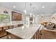 Kitchen showcases granite countertops, dark cabinets, and an island with bar seating, open to the living room at 2167 Dodson Woods Dr, Fairburn, GA 30213