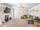 Bright living room featuring a fireplace, large TV, ceiling fan, and comfortable seating arrangement at 2167 Dodson Woods Dr, Fairburn, GA 30213