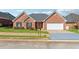 Charming single-story brick home featuring an attached two-car garage, well-manicured lawn, and a welcoming entryway at 219 Prominent Loop, Mcdonough, GA 30253